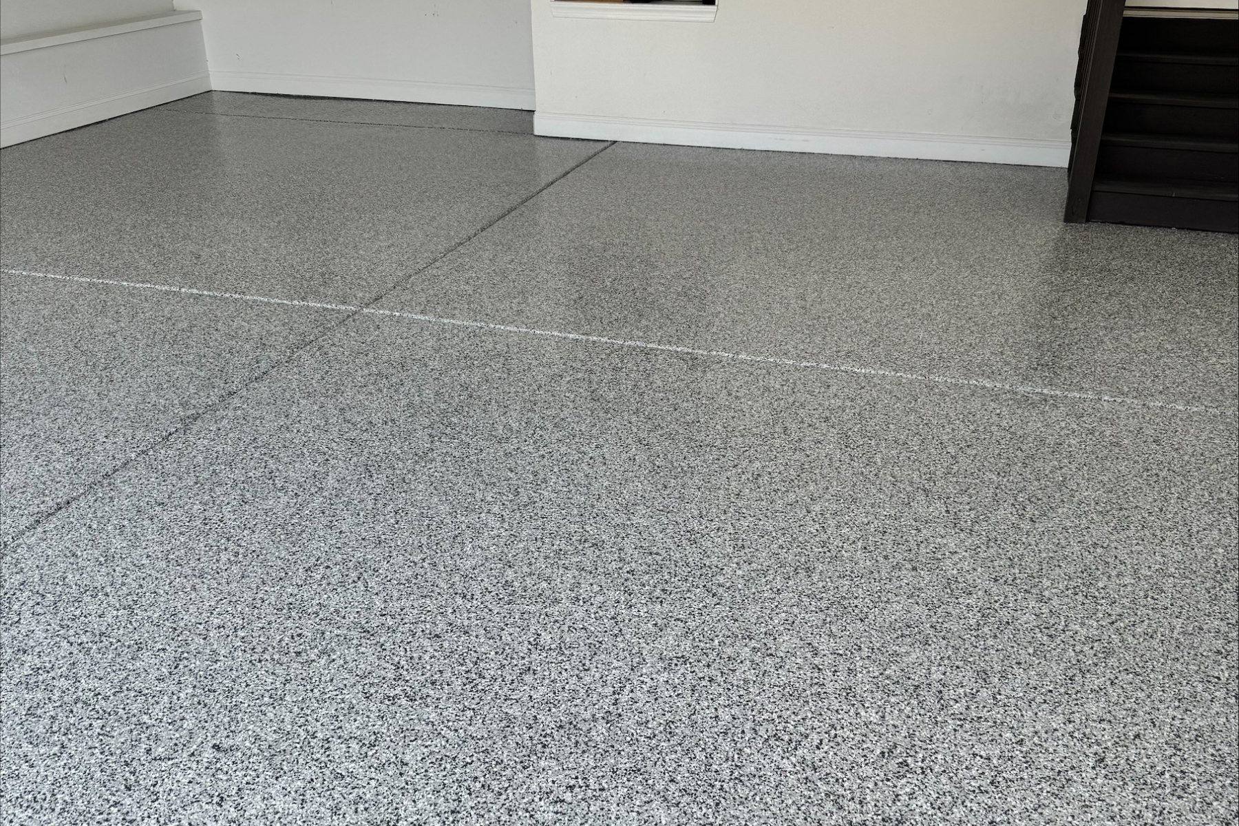 residential garage finished with arctic ash flake epoxy flooring and smooth uniform surface