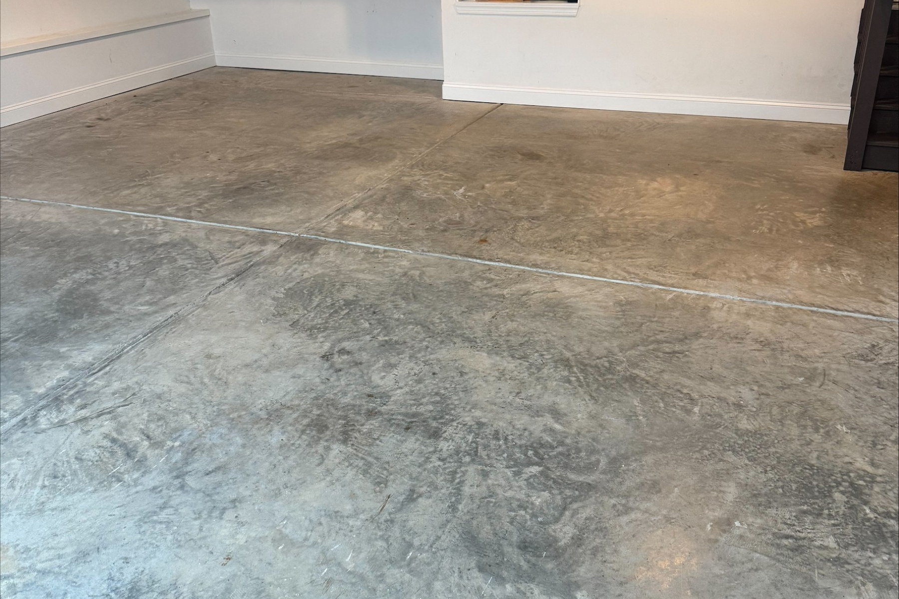 residential garage with exposed concrete slab showing surface wear and discoloration before epoxy floor installation