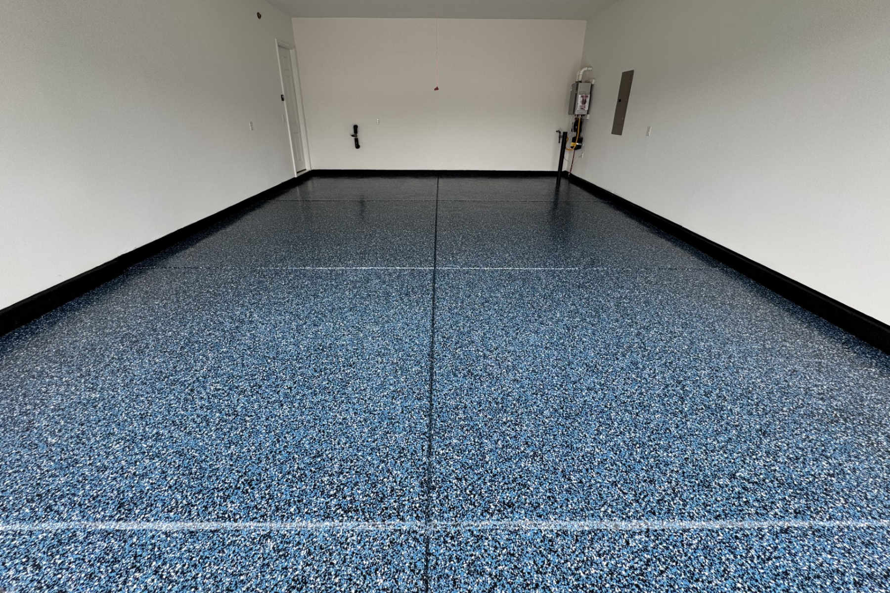 residential garage with blue and white speckled epoxy floor coating and sealed concrete surface