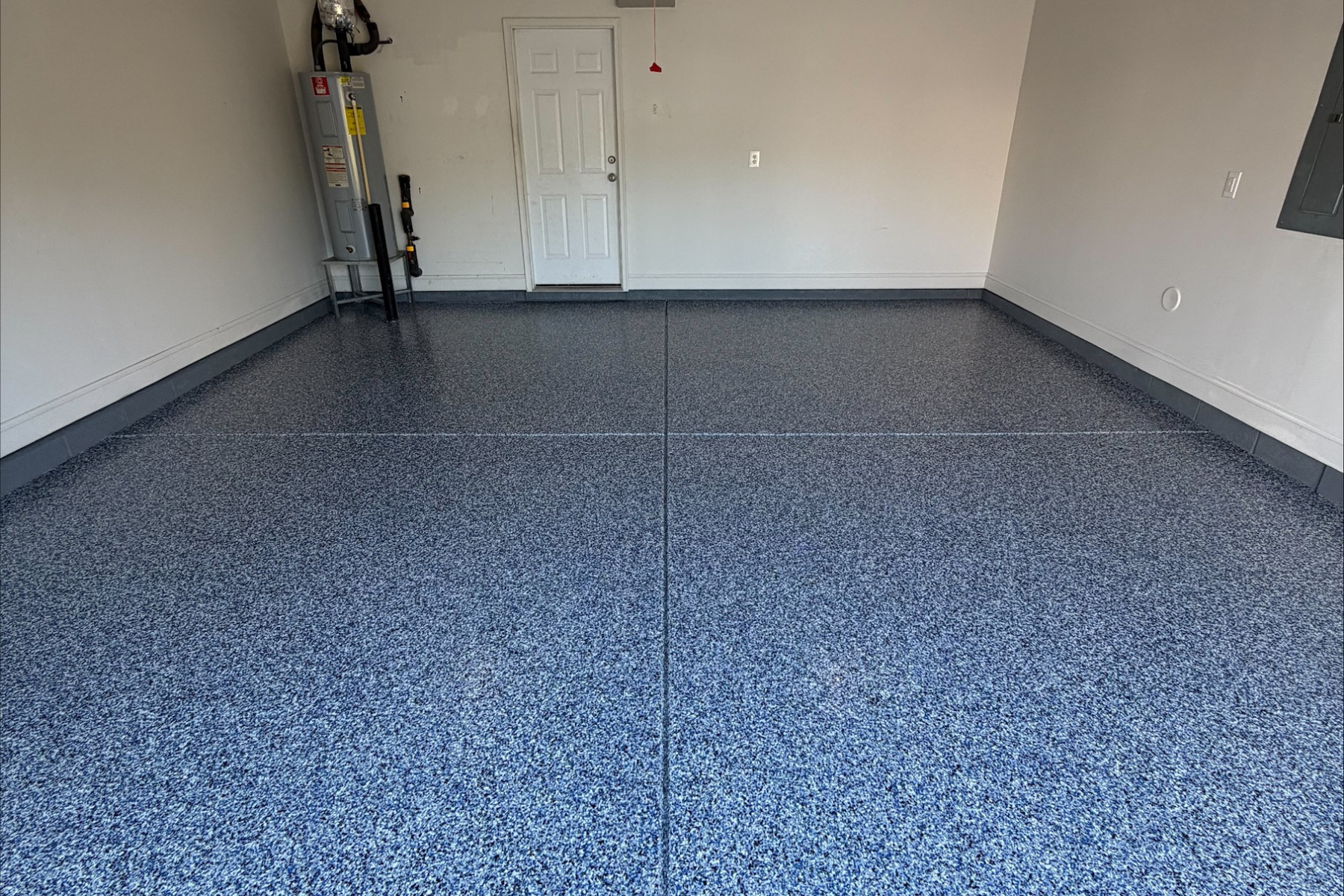 residential garage with coastal blue flake epoxy flooring and evenly finished concrete surface