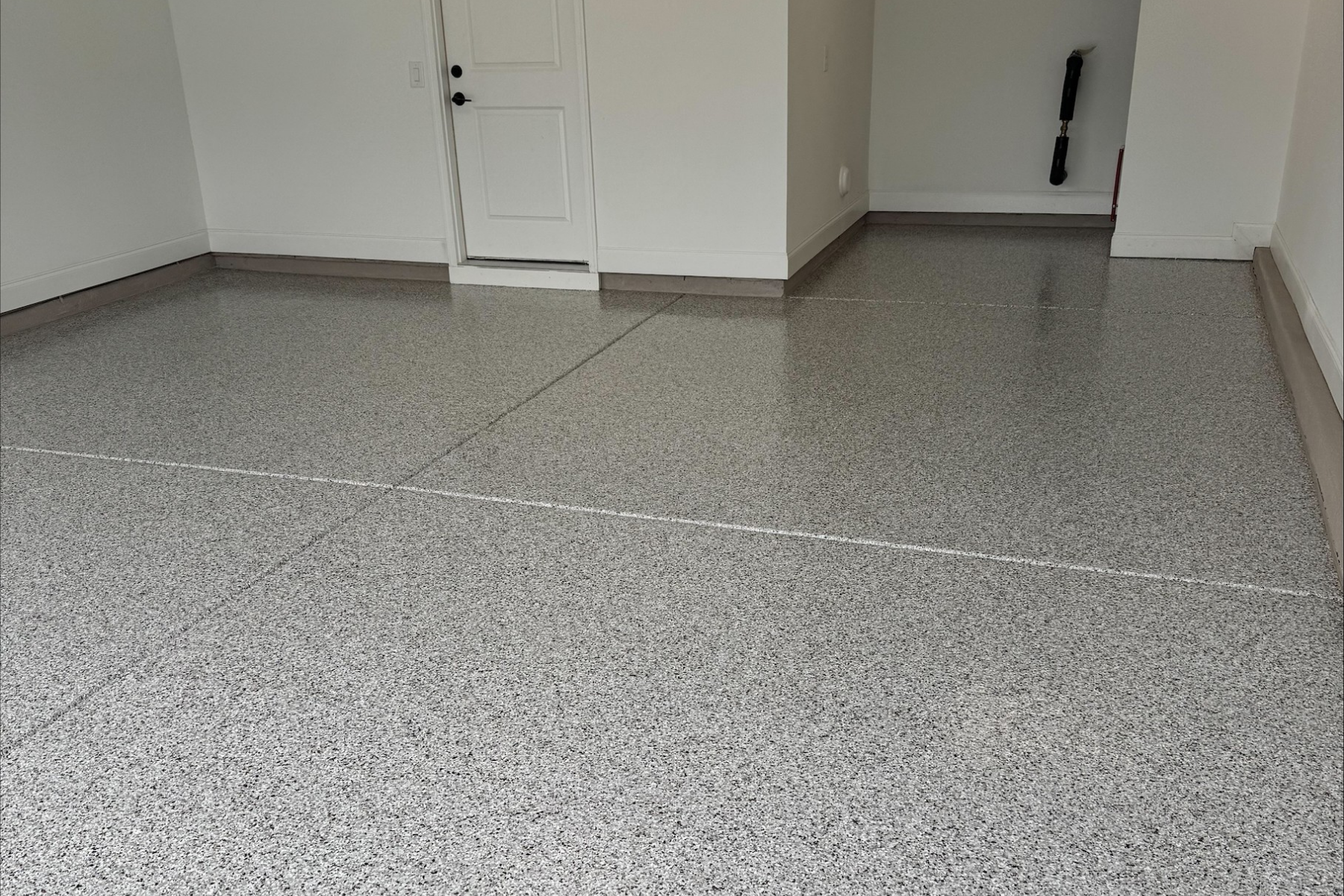 light gray flake epoxy floor installed in residential garage