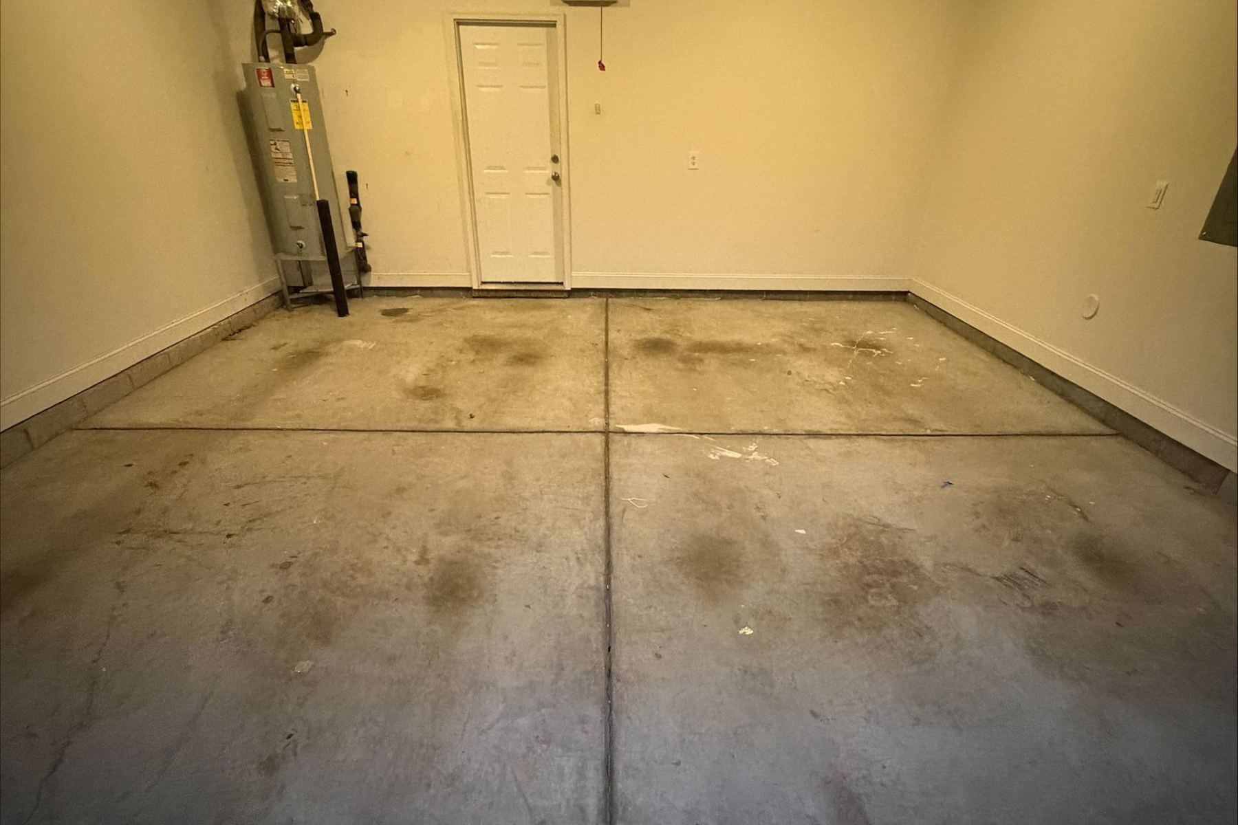 residential garage with concrete floor showing oil stains and surface wear before epoxy floor installation